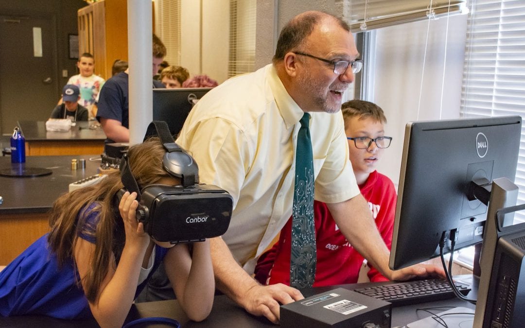 Dr. Gallis assists students with VR at computer