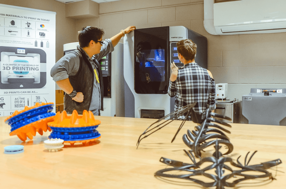 students wait for 3D printed models to finish in lab space