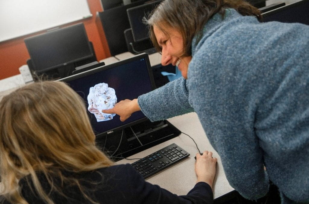 Instructor points to 3D model on student's computer