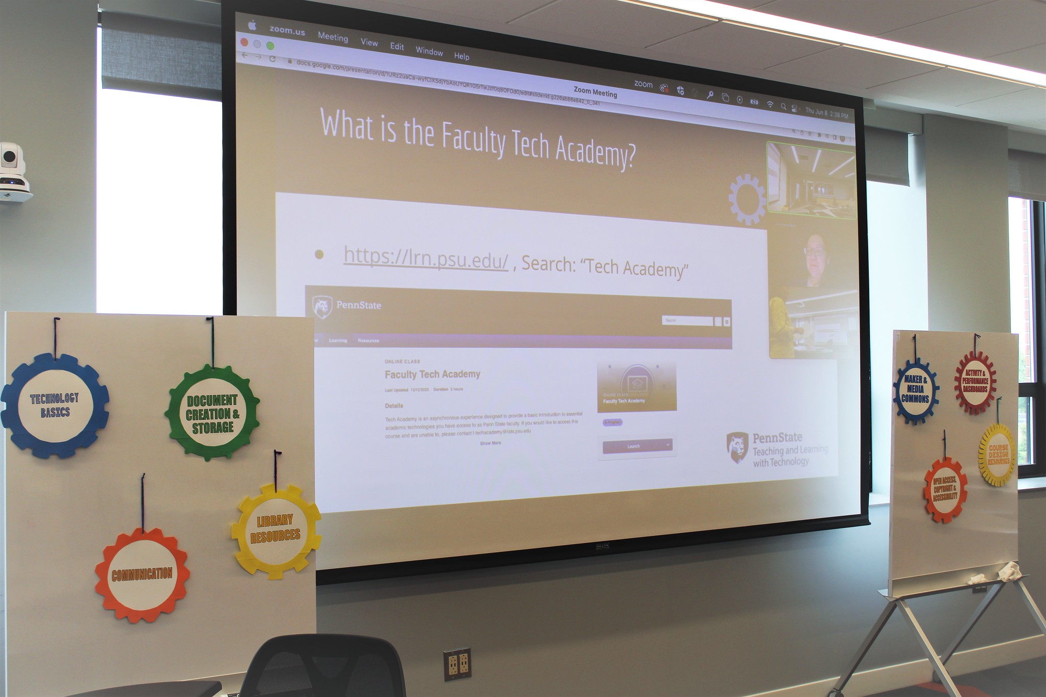 lrn-image Presentation screen with "What is tech academy" slide and online presenters visible, flanked by posterboards